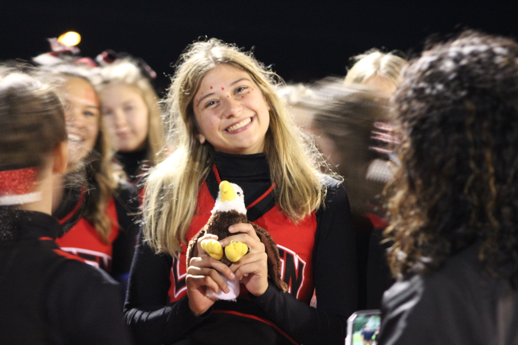 Smiling cheerleader holding a stuffed eagle