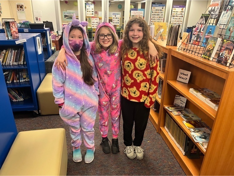 Three young girls wearing colorful pajamas
