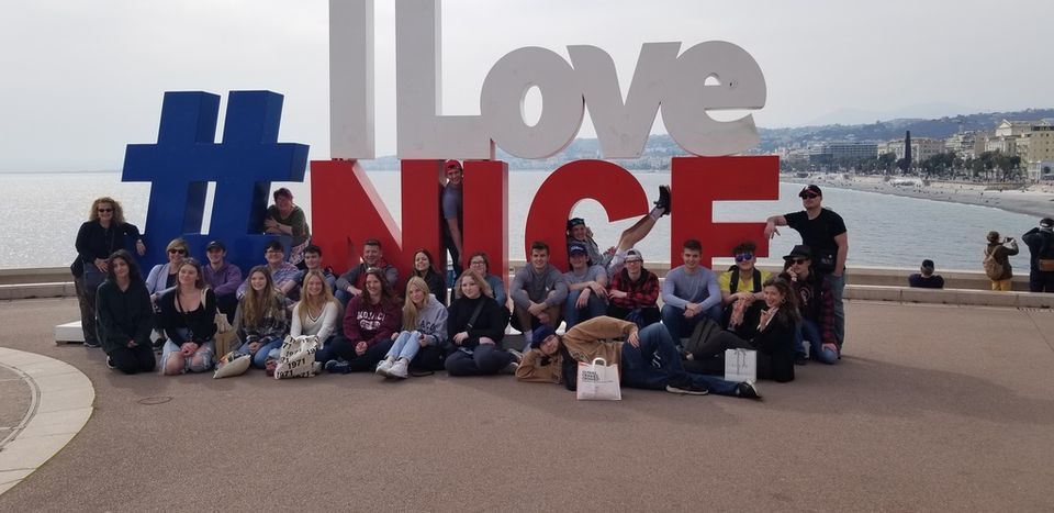 Students in Nice France in front of a sign that says #I Love Nice