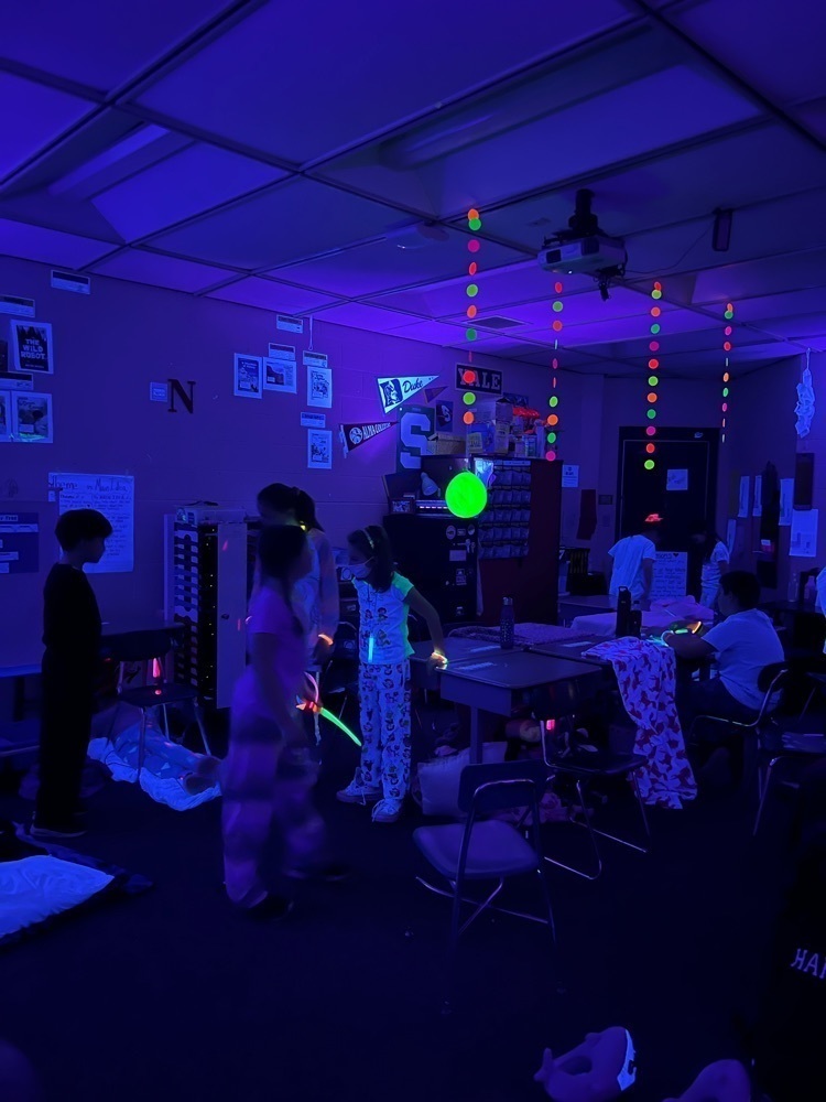 Students in a dark room with glow sticks