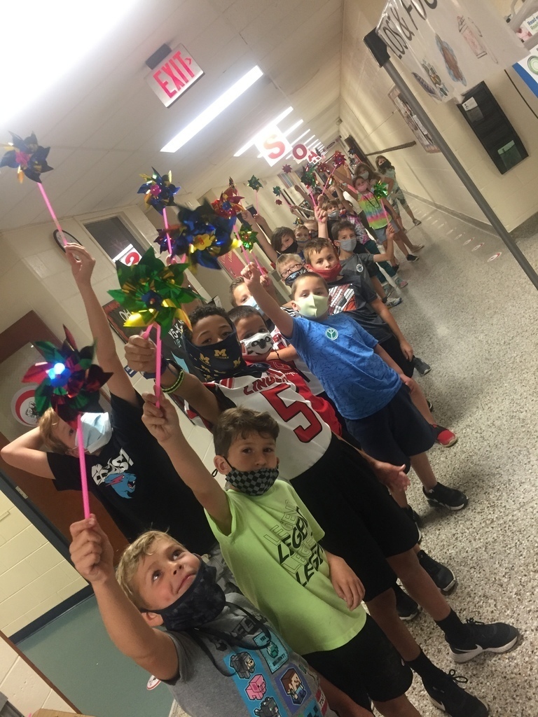 Students lined up in the hallway holding pinwheels