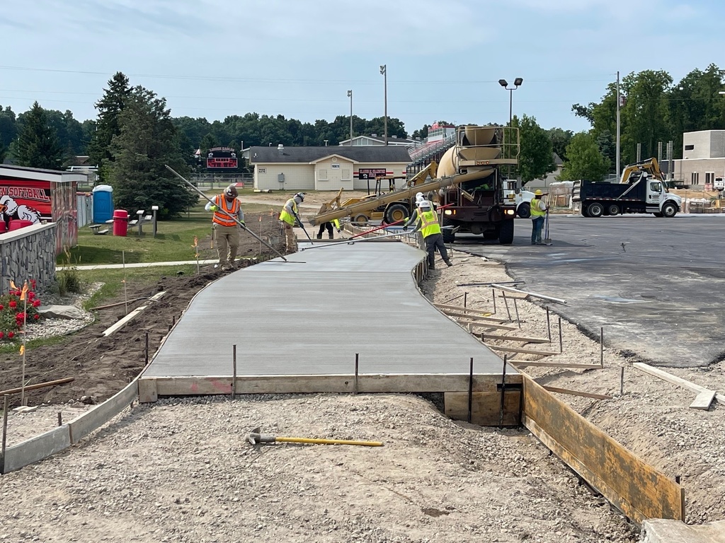 Construction workers pouring concrete for the walkway in the Linden High School Student Parking Lot