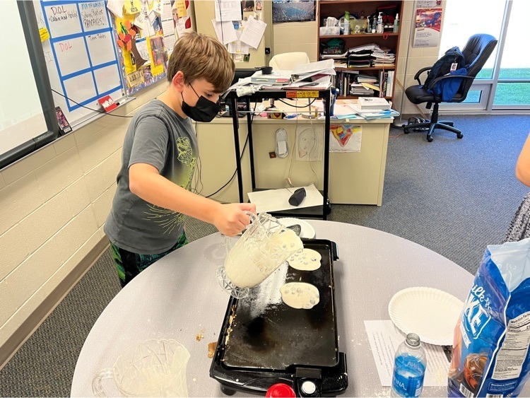 student making pancakes on a griddle 