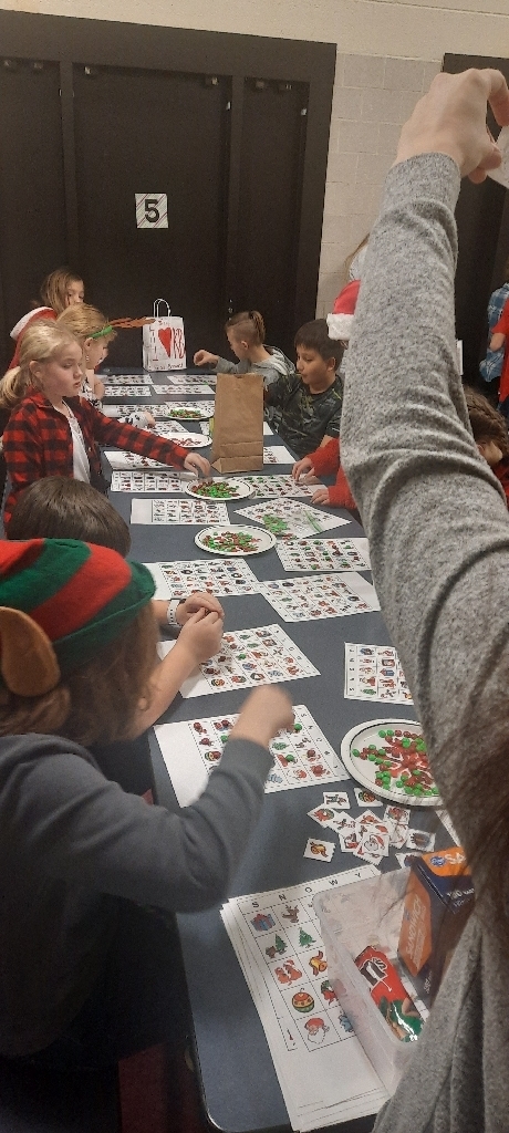 table with many students and holiday themed bingo cards.