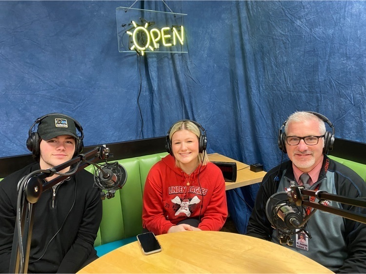 students and adult sitting doing a podcast