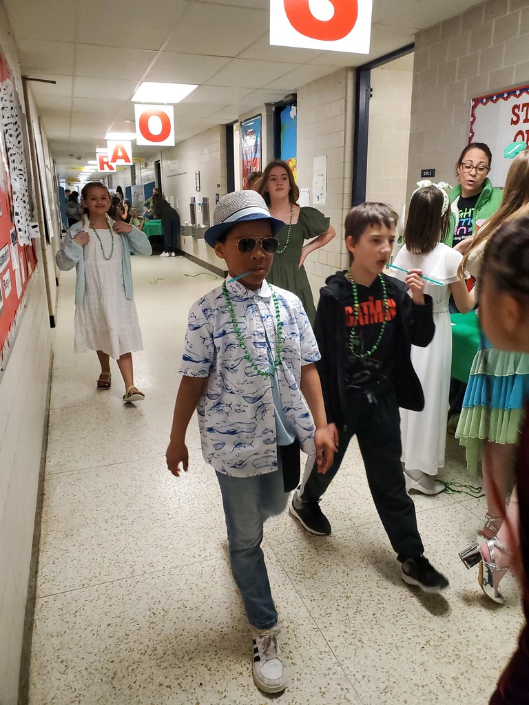 Many student walking through hallway and playing games.